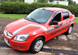 Conforme legislação, táxis terão que utilizar a cor vermelha predominante, com uma faixa prata com desenhos de edifícios da cidade e outra quadriculada em branco e preto